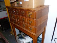 A BANK OF FIFTEEN OAK FILE DRAWERS RAISED ON SQUARE TAPERED LEG. W.84 x H.115cms.