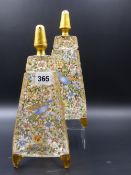 A PAIR OF MOSER STYLE TRIANGULAR SHAPED EAU DE COLOGNE GLASS JARS DECORATED WITH ENAMEL SCENES OF