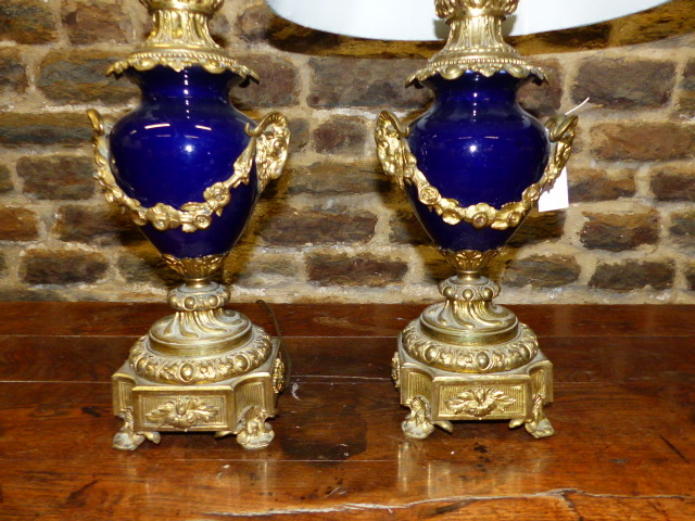 A PAIR OF ANTIQUE FRENCH ORMOLU MOUNTED VASES ADAPTED TO TABLE LAMPS WITH RAM'S HEAD HANDLES AND