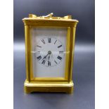 A FRENCH GILT BRASS CARRIAGE CLOCK WITH 1/4 CHIMING MOVEMENT AND STRIKE REPEAT, WHITE ENAMEL DIAL.