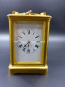 A FRENCH GILT BRASS CARRIAGE CLOCK WITH 1/4 CHIMING MOVEMENT AND STRIKE REPEAT, WHITE ENAMEL DIAL.