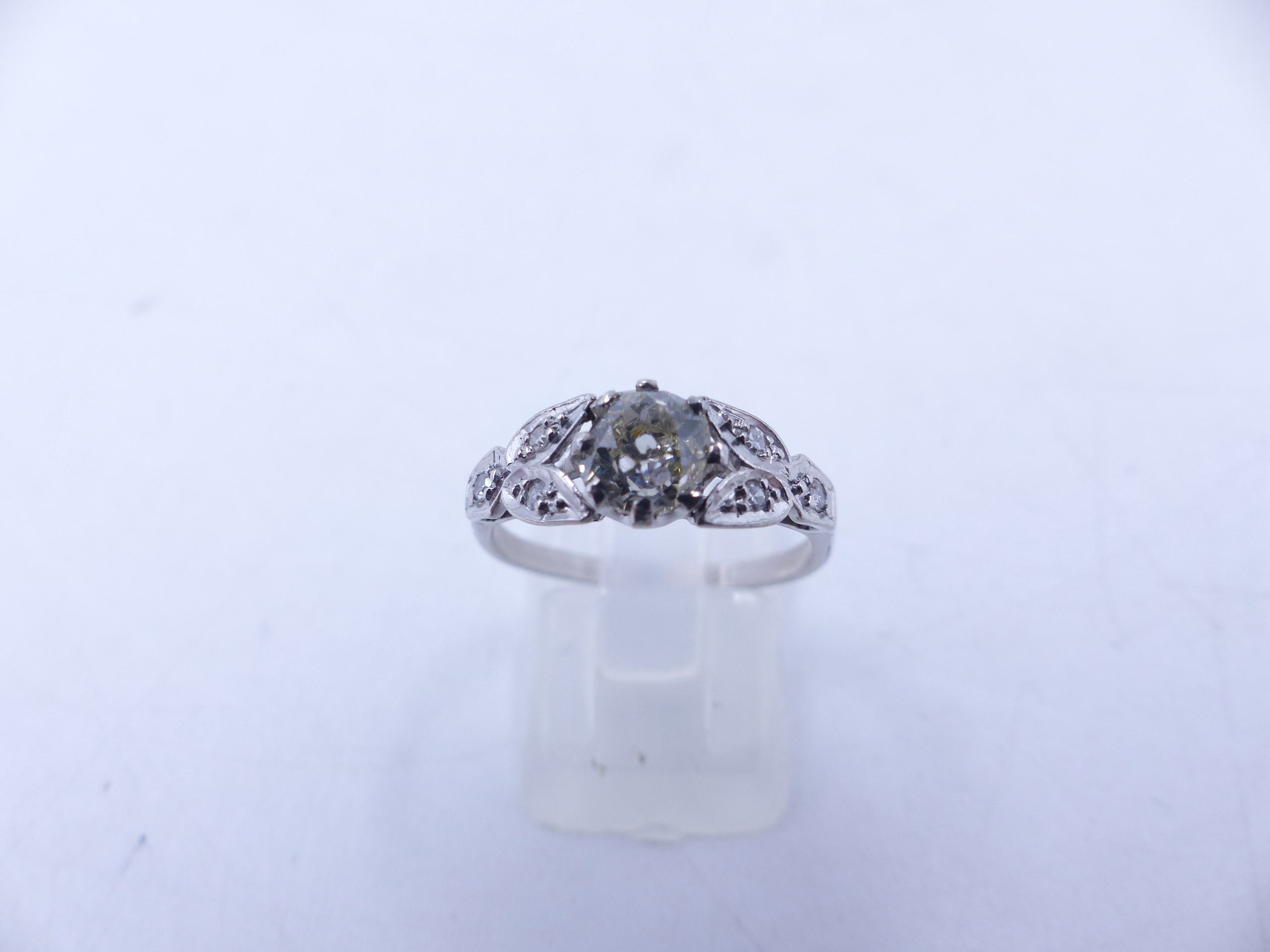 AN 18ct STAMPED OLD CUT DIAMOND RING. THE CENTRAL OLD CUT DIAMOND IS HELD IN AN EIGHT CLAW SETTING