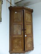 A GOOD QUALITY COTSWOLD SCHOOL ARTS AND CRAFTS WALNUT TWO DOOR CORNER CABINET.