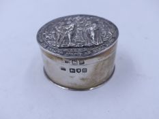 A SILVER HALLMARKED CIRCULAR TRINKET BOX WITH A HINGED COVER, DEPICTING A BIBLICAL SCENE, DATED