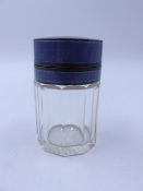 A GEORGE V SILVER TOPPED FACETED GLASS DRESSING TABLE JAR WITH STOPPER. THE PURPLE GUILLOCHE