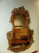 A 19th.C. FRENCH LOUIS XV STYLE GILT CARTOUCHE FORM MIRROR. H.136cms. W.98cms.