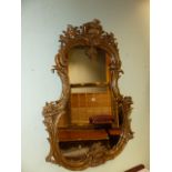 A 19th.C. FRENCH LOUIS XV STYLE GILT CARTOUCHE FORM MIRROR. H.136cms. W.98cms.