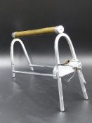 AN INTERESTING ART DECO FRENCH CHROME WINE BOTTLE CRADLE.