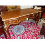 A FRENCH LOUIS XV STYLE ORMOLU MOUNTED SERPENTINE FORM WRITING TABLE WITH THREE APRON DRAWERS. H.