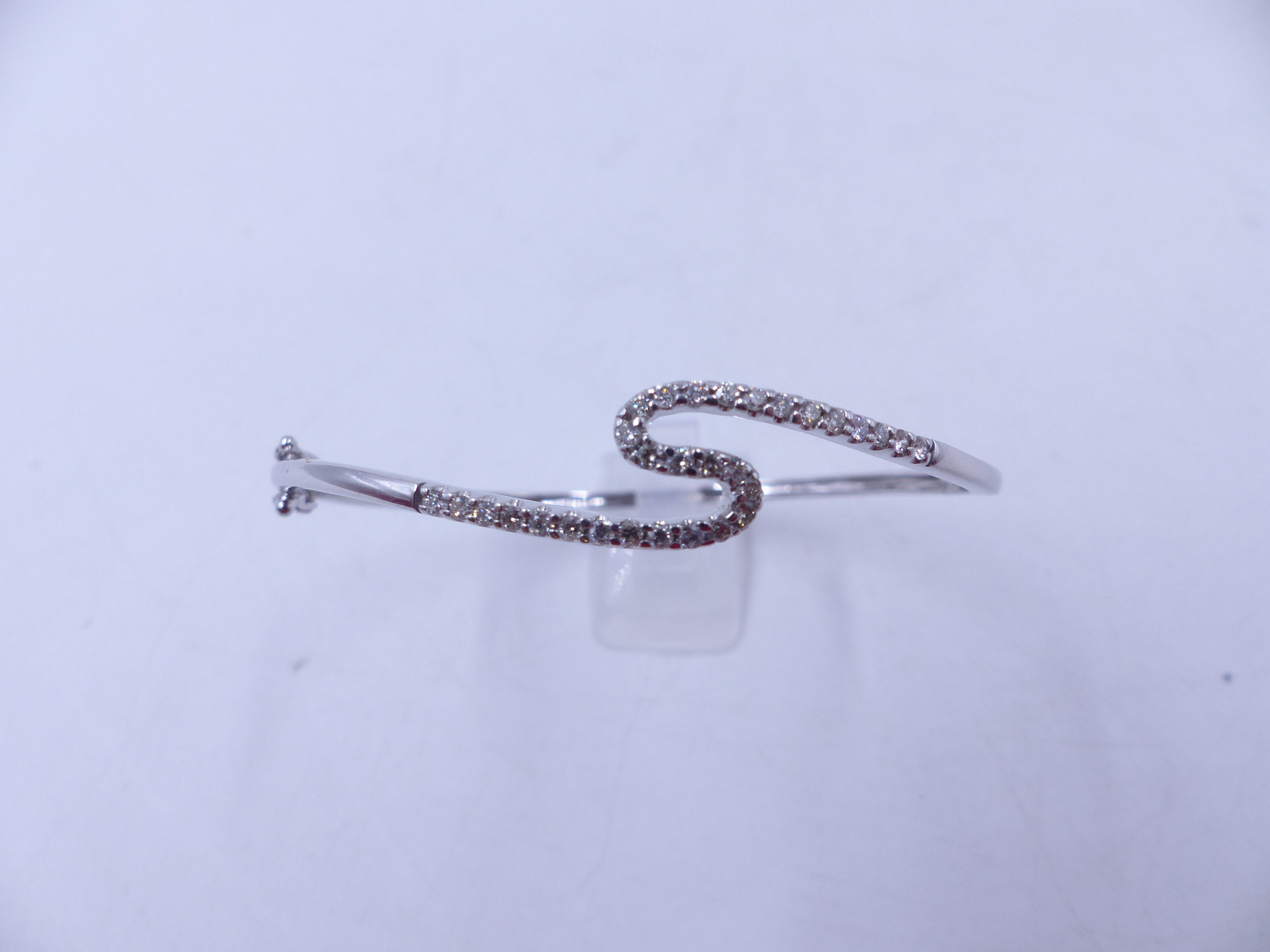 A WHITE METAL (TESTS AS GOLD) DIAMOND HINGED BANGLE COMPLETE WITH TWO FIGURE OF EIGHT SAFETY CLASPS. - Image 6 of 6