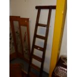 AN ANTIQUE PINE LIBRARY LADDER.