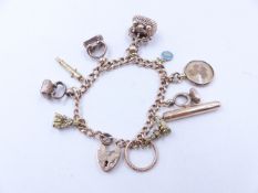 A 625 STAMPED 15ct GOLD CURB CHAIN CHARM BRACELET COMPLETE WITH A 9ct PADLOCK AND ELEVEN VARIOUS