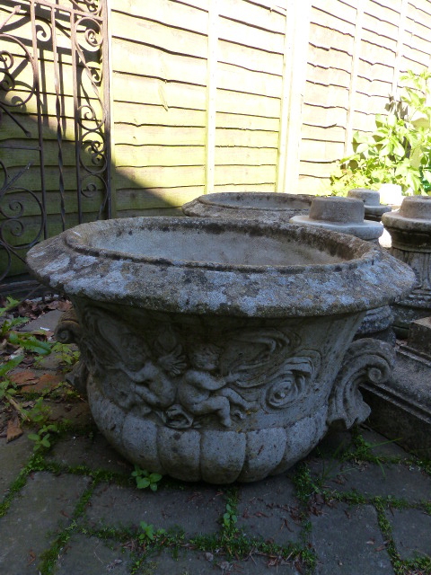TWO PAIRS OF LARGE GARDEN URNS ON SHAPED PEDESTAL SUPPORTS.