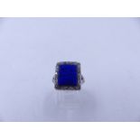 AN 18ct STAMPED WHITE METAL RING SET WITH A CENTRAL LAPIS LAZULI AND A HALO OF OLD CUT DIAMONDS.