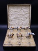 A CASED SET OF SIX ENAMELLED COCKTAIL GLASSES DECORATED WITH FIGHTING COCKS.