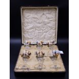 A CASED SET OF SIX ENAMELLED COCKTAIL GLASSES DECORATED WITH FIGHTING COCKS.