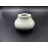 A CHINESE PALE CELADON SQUAT FORM MINIATURE VASE WITH SEAL MARK TO BASE. H.4.5cms.