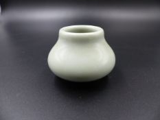 A CHINESE PALE CELADON SQUAT FORM MINIATURE VASE WITH SEAL MARK TO BASE. H.4.5cms.