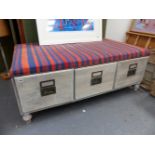 A LARGE LIMED OAK LOW STOOL FITTED WITH THREE DEEP DRAWERS. W.133 x D.82 x H.51cms.