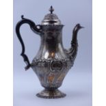 A VICTORIAN SILVER HALLMARKED COFFEE POT OF BALUSTER FORM CHASED WITH A FLORAL DECORATION DATED