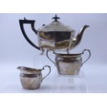 A SILVER THREE PIECE TEA SET COMPRISING OF AN ART DECO TEAPOT DATED 1930 TOGETHER WITH A CREAMER AND