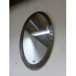 AN ARTS AND CRAFTS BRASS FRAMED OVAL WALL MIRROR.