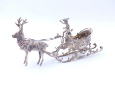 A CONTINENTAL SILVER MODEL OF A REINDEER PULLING A SLED SURMOUNTED BY A PUTTO. MEASUREMENTS 16cms