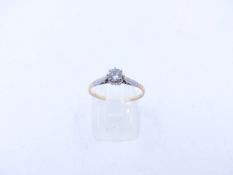 AN 18ct STAMPED YELLOW GOLD DIAMOND SOLITAIRE RING WITH WHITE METAL SHOULDERS. THE SOLITAIRE BEING A