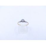 AN 18ct STAMPED YELLOW GOLD DIAMOND SOLITAIRE RING WITH WHITE METAL SHOULDERS. THE SOLITAIRE BEING A