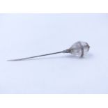 A CRYSTAL AND DIAMOND SET FLUTED ORB STICK PIN. MEASUREMENTS 7.5cms.