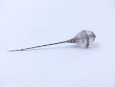 A CRYSTAL AND DIAMOND SET FLUTED ORB STICK PIN. MEASUREMENTS 7.5cms.