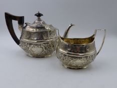 A VICTORIAN SILVER CHASED AND HALLMARKED TEAPOT AND SUGAR, ENGRAVED ON ONE SIDE 1873-1898 AND ON THE