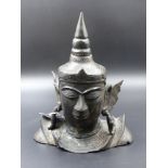 AN ASIAN BRONZE HEAD OF A DEITY WITH STYLISED FEATURES AND A KNOP HEAD DRESS. H.22cms.