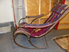 AN ANTIQUE WROUGHT IRON AND BRASS ROCKING CHAIR WITH KELIM SLING UPHOLSTERED SEAT, AFTER A DESIGN BY