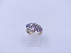 A 9ct YELLOW GOLD DIAMOND AND LAVENDER GEMSTONE DRESS RING. FINGER SIZE J, WEIGHT 2.4grms.