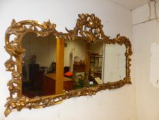 A 19th.C.CARVED GILTWOOD WALL MIRROR. W.133 x H.71cms.