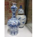 A CONTINENTAL DELFT POTTERY VASE WITH ELONGATED NECK DEPICTING AN ORIENTAL PAINTED SCENE. H.38cms