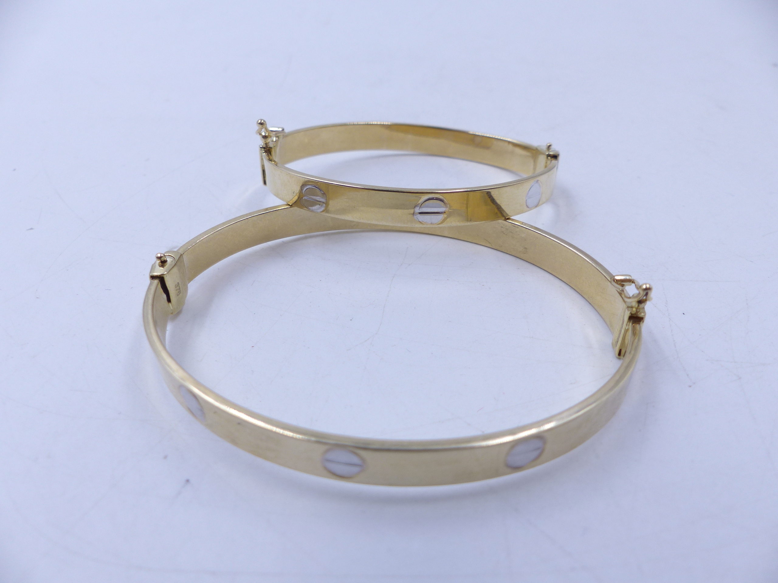 A MATCHING PAIR OF HINGED 9ct CARTIER STYLE BANGLES, ONE ADULT SIZE AND ONE CHILDS SIZE. TOTAL GROSS - Image 8 of 8