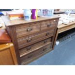 AN OAK CHEST OF DRAWERS.