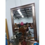 A SILVERED FRAME WALL MIRROR.