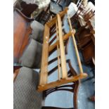 AN ERCOL ELM PLATE RACK AND A LACQUERED TWO TIER TABLE.