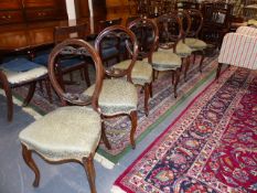 A SET OF SIX VICTORIAN BALLOON BACK CHAIRS WITH CARVED AND PIERCED DECORATION, OVERSTUFFED SEATS AND