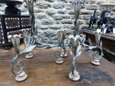 A PAIR OF CONTINENTAL DECORATED WROUGHT IRON FOUR LIGHT TABLE CANDELABRA OF SCROLL FORM WITH