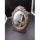 A SILVER MOUNTED OVAL BEVELLED GLASS MIRROR ON AN OAK EASEL BACKED STAND. BIRMINGHAM 1904. H.31.