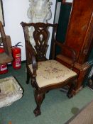 AN ANTIQUE MAHOGANY ARMCHAIR IN THE GEORGIAN TASTE, PIERCED SPLAT BACK ON BALL AND CLAW FEET