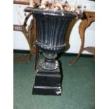 A PAIR OF PAINTED CAST IRON FLUTED CAMPAGNA FORM GARDEN URNS ON STEPPED PLINTH BASES. H.69cms.