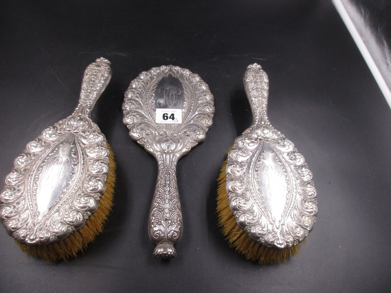 A TIFFANY AND CO STERLING THREE PART VANITY SET, HAND CHASED WITH REPOUSSE DECORATION AND A