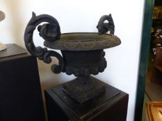 A VICTORIAN CAST IRON TWIN HANDLED URN.