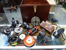 A COLLECTION OF FISHING REELS TO INCLUDE SHAKESPEARE, ABU AND OTHERS IN A DARK WOOD BOX WITH BRASS