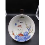 A JAPANESE IMARI BOWL PAINTED WITH BUTTERFLIES AND FLOWERS WITH WOODEN STAND. Dia.24.5cms.